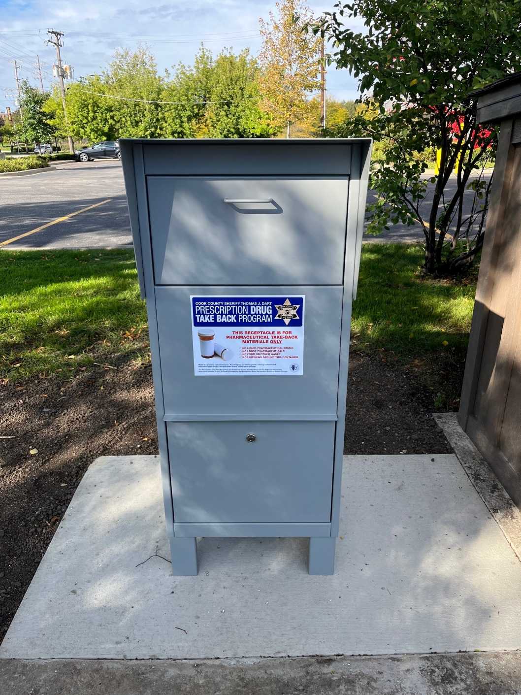 A gray mailbox featuring a sign attached to its front - Copy